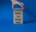 Teamwork symbol. Wooden blocks with words Teamwork makes the Dream work. Businessman hand. Beautiful blue background. Business and Royalty Free Stock Photo