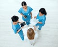 Teamwork, tablet or above of doctors in meeting planning a surgery strategy in collaboration together. Top view of