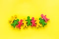 Teamwork, teambuilding concept. Wooden figures of people on yellow background top view