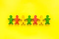Teamwork, teambuilding concept. Wooden figures of people on yellow background top view