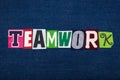 TEAMWORK text word collage, multi colored fabric on blue denim, team effort concept