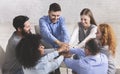 Happy people sitting in trust circle and putting hands together Royalty Free Stock Photo