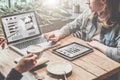 Teamwork, two young business woman sitting at table,drinking coffee and working online. Royalty Free Stock Photo