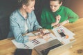 Teamwork.Two young business women sitting at table. Girl shows colleague information on smartphone screen. Royalty Free Stock Photo