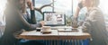 Teamwork, two young businesswomen sitting across table from each other. On table laptop, coffee cup and tablet computer. Royalty Free Stock Photo