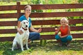 Teamwork - woman with little girl and dog painting a fence Royalty Free Stock Photo