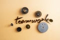 Teamwork written on textured glass, with tiny gears, representing \