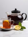 Teapot and cup of black tea with slice of lemon. Royalty Free Stock Photo