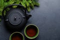 Teapot, cup, and fir tree branches create a cozy scene