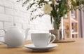 Teapot, cup and flowers on wooden dining table. Kitchen interior Royalty Free Stock Photo