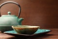 Teapot and cup of freshly brewed tea on wooden table, closeup. Traditional ceremony Royalty Free Stock Photo