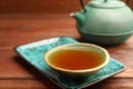 Teapot and cup of freshly brewed tea on wooden table, closeup. Traditional ceremony Royalty Free Stock Photo