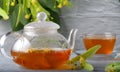 Teapot and cup with linden tea and flowers on a wooden table against a brick wall background Royalty Free Stock Photo