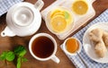 Teapot and cup of tea with lemon, ginger and mint