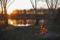 Teapot on the fire prepares tea. Orange sunset Royalty Free Stock Photo