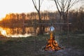 Teapot on the fire prepares tea. Orange sunset Royalty Free Stock Photo