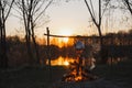 Teapot on the fire prepares tea. Orange sunset Royalty Free Stock Photo