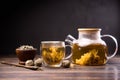 Teapot and glass cup with blooming tea flower inside on a wooden table Royalty Free Stock Photo