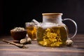 Teapot and glass cup with blooming tea flower inside on a wooden table Royalty Free Stock Photo