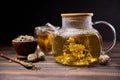 Teapot and glass cup with blooming tea flower inside on a wooden table Royalty Free Stock Photo