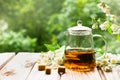 Teapot with jasmine tea and flowers on the wood background Royalty Free Stock Photo