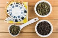 Teapot on napkin, bowls and white spoon with dry tea