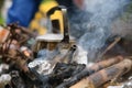 Teapot over the fire. Beautiful campfire in a tourist camp in the summer forest. Royalty Free Stock Photo