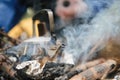 Teapot over the fire. Beautiful campfire in a tourist camp in the summer forest. Royalty Free Stock Photo