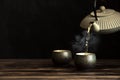 Teapot pouring tea into cups Royalty Free Stock Photo