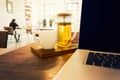 Teapot, teacup, and laptop computer on wooden desk