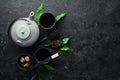 Teapot and two cups of tea on a black stone background. Royalty Free Stock Photo