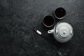 Teapot and two cups of tea on a black stone background. Top view. Royalty Free Stock Photo