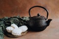 Teapot, zephyr sweet dessert on silver platter and decorative napkin. Tea time background.