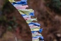 Tear colorful Tibetan prayer flags waving and swaddled with bridge over frozen river at Thangu and Chopta valley in winter. Royalty Free Stock Photo