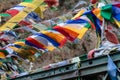 Tear colorful Tibetan prayer flags waving and swaddled with bridge over frozen river at Thangu and Chopta valley in winter. Royalty Free Stock Photo