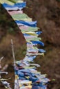 Tear colorful Tibetan prayer flags waving and swaddled with bridge over frozen river at Thangu and Chopta valley in winter. Royalty Free Stock Photo