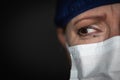 Tearful Stressed Female Doctor or Nurse Crying Wearing Medical Face Mask on Dark Background