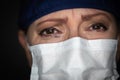 Tearful Stressed Female Doctor or Nurse Crying Wearing Medical Face Mask on Dark Background