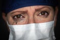 Tearful Stressed Female Doctor or Nurse Crying Wearing Medical Face Mask on Dark Background