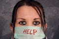Tearful woman - medical worker - with blurry eyes and mask with inscription HELP. Doctor or nurse helping patients with covid-19.