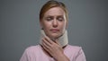 Tearful woman touching cervical collar on her neck, trauma of cervical spine