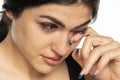 Tearful young woman wipes her tears with her hand