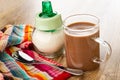 Spoon on napkin, sugar bowl, cocoa with milk in cup on wooden table