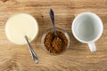 Spoon  condensed milk in bowl  spoon in bowl with instant coffee  empty cup on wooden table. Top view Royalty Free Stock Photo