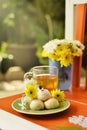 Teatime with Chinese pastry and tea and flower on a orange chair