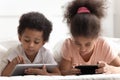 Tech addicted children using smartphone and tablet.