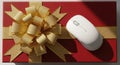 Tech gift idea white computer mouse on red gift box with gold bow Royalty Free Stock Photo