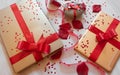 tech gifts tablet, smart speaker and laptop wrapped with red bow, rose petals and hearts