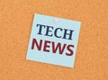 TECH NEWS written on sticky note paper over a kork board. Business concept for newly received or noteworthy information about Royalty Free Stock Photo