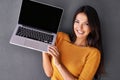 Tech-savvy beauty. Portrait of an attractive young woman holding up a laptop with a blank screen. Royalty Free Stock Photo